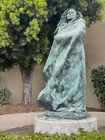 Téléchargez les photos : Santa Barbara, CA, États-Unis - 19 janvier 2024 : Statue en bronze vert de Juana Maria and Child close seup. Feuillage vert à l'arrière. Femme seule de l'île San Nicolas, alias Sacagawea - en image libre de droit
