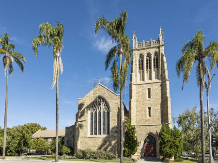 Photo for Santa Barbara, CA, USA - November 30, 2023: Landscape, brown stone Trinity Episcopal Church with tower on State Street under blue sky. Trees and plants in front. - Royalty Free Image