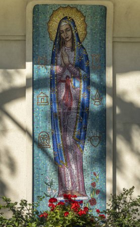 Photo for Santa Barbara, CA, USA - November 30, 2023: Trinity Episcopal Church, closeup of large colorful mosaic featuring image of Mother Mary on facade of pastor house. Red flowers and green - Royalty Free Image