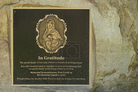 Foto de Santa Barbara, CA, EE.UU. - 30 de noviembre de 2023: Iglesia Nuestra Señora de los Dolores, primer plano de la placa en la cruz conmemorativa gigante, celebrando la reapertura después de Covid-19. Oro sobre negro engastado en roca - Imagen libre de derechos