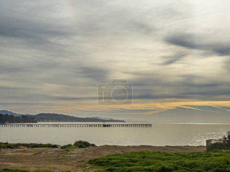 Foto de Santa Barbara, California, EE.UU. - 10 de marzo de 2024:: Panorama Amplio, Parches Amarillos en nubes grises de la mañana sobre el Muelle de Goleta. Océano Pacífico Gris, cerca de UCSB. - Imagen libre de derechos