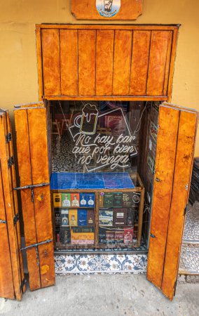 Photo for Cartagena, Colombia - July 25, 2023: Liqour store in Calle 30 has counter in street side display window. Bottle boxes on display - Royalty Free Image