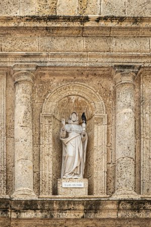 Cartagena, Colombia - July 25, 2023: Closeup, White statue of San Luis Beltran, Louis Bertrand, in brown-beige stone niche above entrance to Convento de Santa Domingo church.