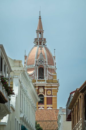 Cartagena, Colombia - July 25, 2023: Cathedral de Santa Catalina de Alejandra. Closeup, Monumental yellow wals, white trims and dome-shaped top of main cathedral tower seen from south