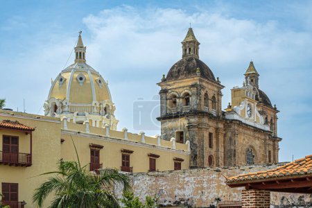 Cartagena, Kolumbien - 25. Juli 2023: Nahaufnahme, Kirchtürme des Santuario de San Pedro Claver, historische Fassade von der Bastion Baluarte de San Ignacio aus gesehen unter blauer Wolkenlandschaft