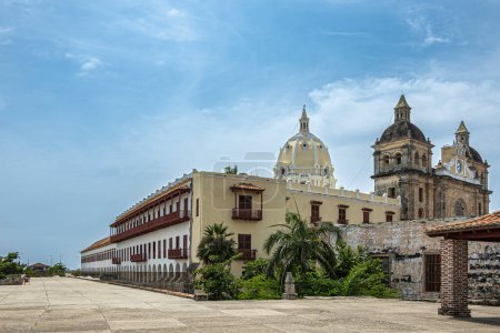 Cartagena, Colombia - July 25, 2023: Santuario de San Pedro Claver church towers, historic front facade with large cloister and archaeological museum buildings on side under blue cloudscape