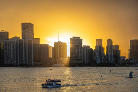 Téléchargez les photos : Miami, Floride, États-Unis - 29 juillet 2023 : Soleil au rez-de-chaussée derrière le boulevard Biscayne 5 de 6, en plein centre, de hauts bâtiments modernes forment la ligne derrière le parc Bayfront et la baie avec des yachts et un bateau de tourisme - en image libre de droit