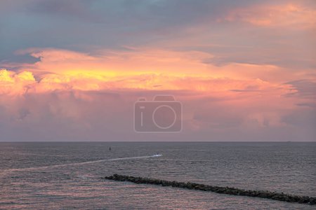 Miami, Florida, Estados Unidos - 29 de julio de 2023: Nube de setas al atardecer sobre el muelle de Fisher Island NE con PWC trazando una línea blanca en aguas grises