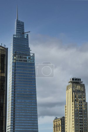 New York, NY, USA - August 2, 2023: One Vanderbilt skyscraper top against blue sky. Worm's eye view