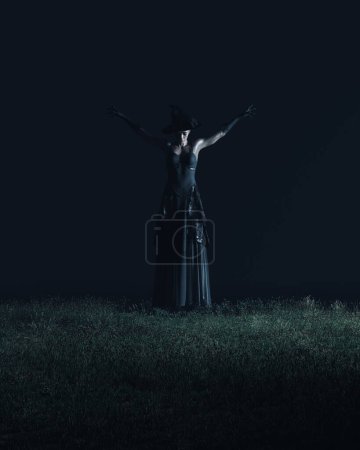 Téléchargez les photos : Sorcière robe noire sorcières chapeau gants Halloween horreur occulte flottant nuit de lévitation au-dessus de l'herbe illustration 3D rendre rendu numérique - en image libre de droit