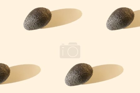 Photo for Avocado on beige pastel background with long shadows. Minimal healthy organic food concept. Banner. Flat lay, top view. Space for text - Royalty Free Image