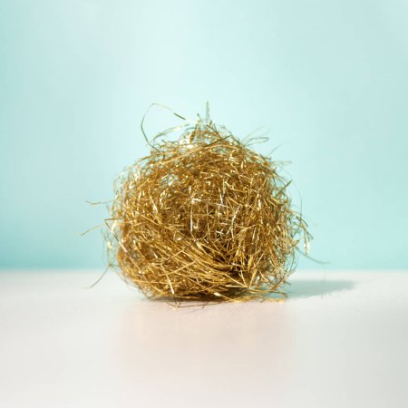 Photo for Golden ball with tinsels on a blue background beige table with shadow. Minimal winter holidays concept - Royalty Free Image