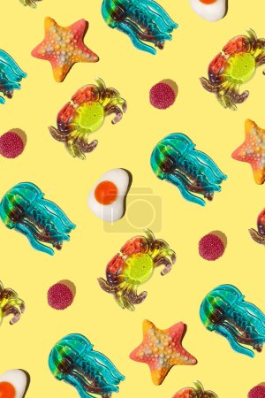 Sweet colorful assorted gummy candy on a yellow background. Jelly sweets. Minimal summer vacation concept