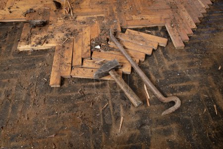 Foto de Herramientas para la eliminación de parquet dañado viejo, martillo, palanca, cincel en tablones viejos - Imagen libre de derechos