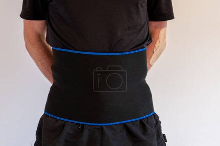 Foto de A man with a support warming belt using to protect spine or weight loss - Imagen libre de derechos