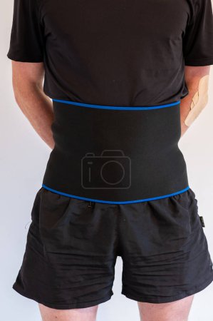 Foto de A man with a support warming belt using to protect spine or weight loss - Imagen libre de derechos