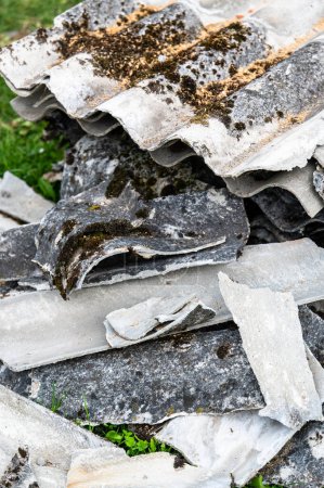 Foto de Un montón de asbesto quitado de un techo viejo. Residuos peligrosos preparados para su eliminación. - Imagen libre de derechos