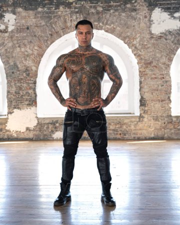 Photo for Muscular athletic sexy male with naked torso. Brutal handsome man with tattooed body. Stylish man. A beautiful and charming guy - Royalty Free Image