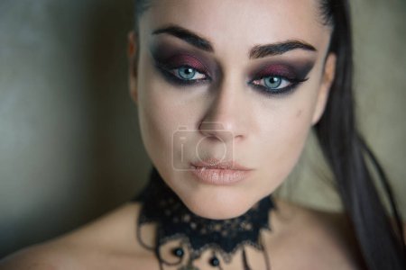 portrait of a beautiful girl close up. woman's face with make-up. a gorgeous woman with blue eyes looks at us. queen. witch. vampire 