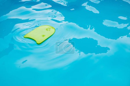 Foto de Nuevo tablero de espuma verde para la práctica de natación en una hermosa piscina sin personas. - Imagen libre de derechos