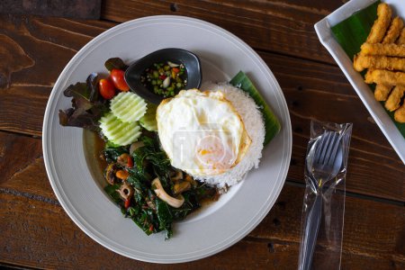 Photo for Stir-Fried Basil and Seafood with Fried Egg on the Wood Table in the Restureant, Delicious Gourmet with Spicy and Tasty. - Royalty Free Image