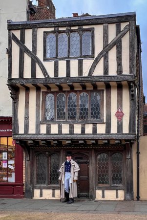 Foto de Antigua fachada del edificio con un hombre disfrazado de época, en la ciudad de Canterbury, Kent, Reino Unido - Imagen libre de derechos