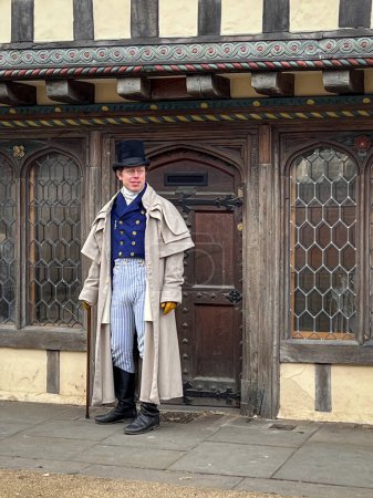 Photo for Man dressed in Dickensian period costume in front of ancient building in the city of Canterbury, Kent, UK - Royalty Free Image