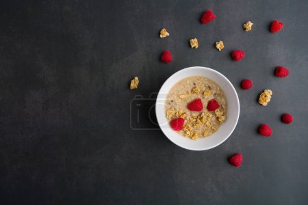 Téléchargez les photos : Healthy breakfast. Fresh granola, muesli with yogurt and raspberry on dark background. Top view. Copy space. - en image libre de droit