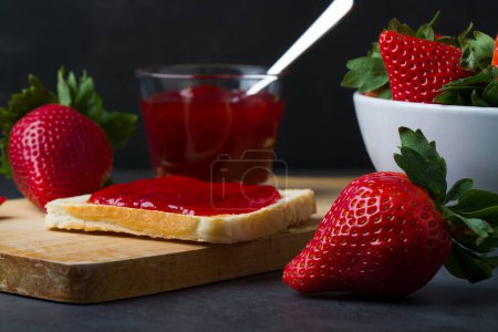 Téléchargez les photos : Confiture de fraises dans le bocal en verre avec des baies fraîches. Gros plan. - en image libre de droit