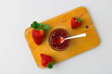 Foto de Una vista de pájaro del pan relleno de mermelada de fresa y fruta de fresa sobre un fondo blanco - Imagen libre de derechos