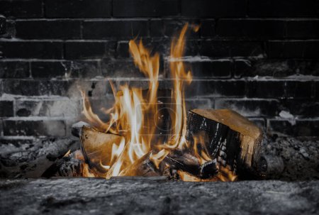 Foto de Leña ardiente en la caja de fuego de la chimenea en la casa de campo. Horno de cocción rústico con leños. - Imagen libre de derechos