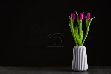 Foto de Boquet de tulipán sobre fondo negro de pie en un jarrón - Imagen libre de derechos