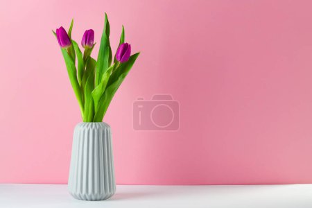 Foto de El entarimado del tulipán sobre el fondo de color melocotón de pie en el florero - Imagen libre de derechos