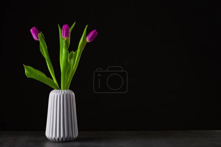 Foto de Boquet de tulipán sobre fondo negro de pie en un jarrón - Imagen libre de derechos