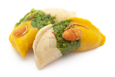 Téléchargez les photos : Deux morceaux de délicieux Tricolore indien doux Khoya Barfi en forme de gujiya. Composé de Mawa, Lait et Sucre isolé sur fond blanc. - en image libre de droit