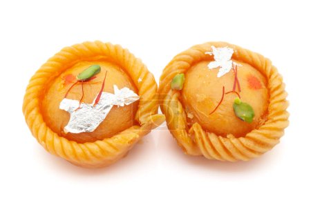 Téléchargez les photos : Deux morceaux de "Chandrakala" doux traditionnel indien, rempli de fruits secs. Vue de face. Isolé sur blanc. - en image libre de droit