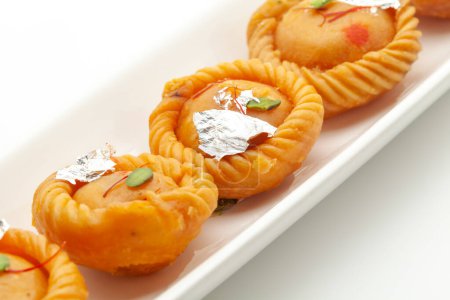 Téléchargez les photos : Gros plan sur Indian Traditional sweet "Chandrakala", rempli de fruits secs, vue de face, isolé sur blanc. - en image libre de droit