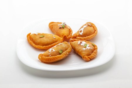 Téléchargez les photos : Indien traditionnel doux "Gujiya", fait pour l'Indien de couleurs "Holi". Le swfestivaleet est fait de maïs (farine), et de ghee, rempli de fruits secs. Vue de dessus, isolé sur blanc. - en image libre de droit