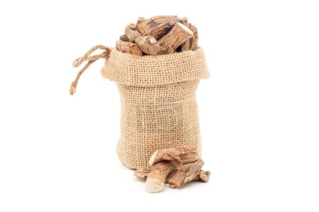Close-up of Dry Sweet flag or Vach (Acorus calamus) roots, in a jute bag. Isolated over white background.