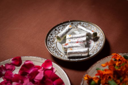 Indian Cashew-rich sweet "Kaju Roll" with flower petals. 