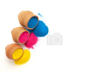 Clay pots filled with various colors of Holi powder spilled out, creating a vibrant display of colors. Isolated on a white background.