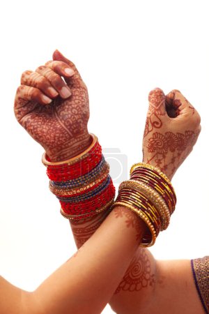 Téléchargez les photos : Deux femmes indiennes avec des tatouages au henné et des bracelets sur leurs belles mains sont représentés lors d'un mariage indien. - en image libre de droit