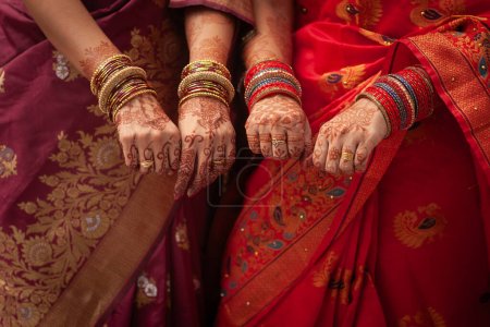 Téléchargez les photos : Concept de cérémonie de mariage indien. Deux femmes portant des sarees et affichant leurs bracelets lors d'une cérémonie de mariage indienne. - en image libre de droit