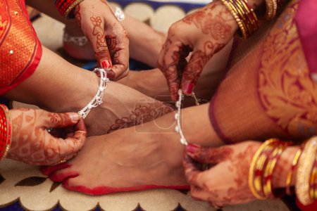Indian Wedding Concept. Zwei Frauen auf einer indischen Hochzeit, die silberne Fußkettchen (Payal) tragen und ihre Füße zeigen.