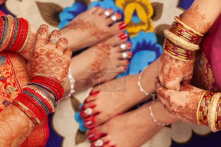 Téléchargez les photos : Concept de mariage indien. Beaux pieds de deux femmes dans un mariage indien, décoré avec une couleur rouge de bon augure (Alta), des bracelets de cheville et des anneaux d'orteils. - en image libre de droit