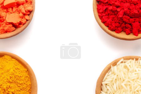 Vista superior de la olla de tierra llena de polvo Color rojo Sindoor, cúrcuma (Haldi), naranja Sindoor, y el arroz, aislado en blanco.