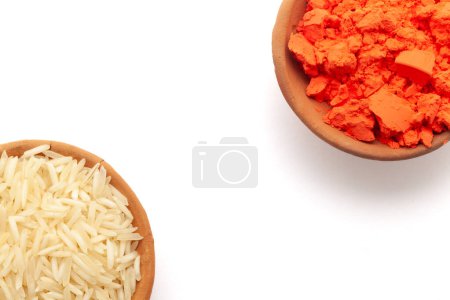Top view of Earthen pot filled with orange sindoor and rice, isolated on white.