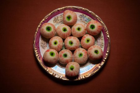 Top view of an Indian Traditional sweet called "khoya apple shaped Mithai" served on a ceramic plate.