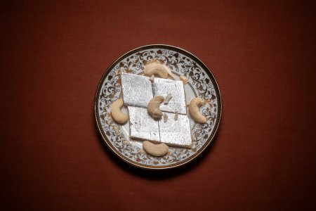Photo for Top view of Indian Cashew-rich sweet "Kaju Katli" served on a ceramic plate. - Royalty Free Image