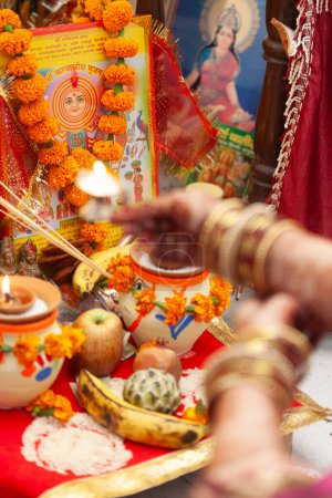 An Indian woman is seen performing aarti, which is a Hindu religious ritual. Indian Hindu puja background.